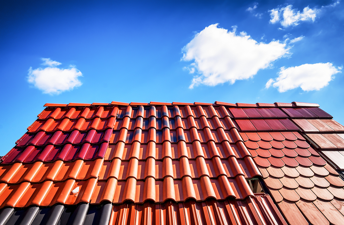 Roof tiles in various shades of orange and brown. Different tile shapes and colors.