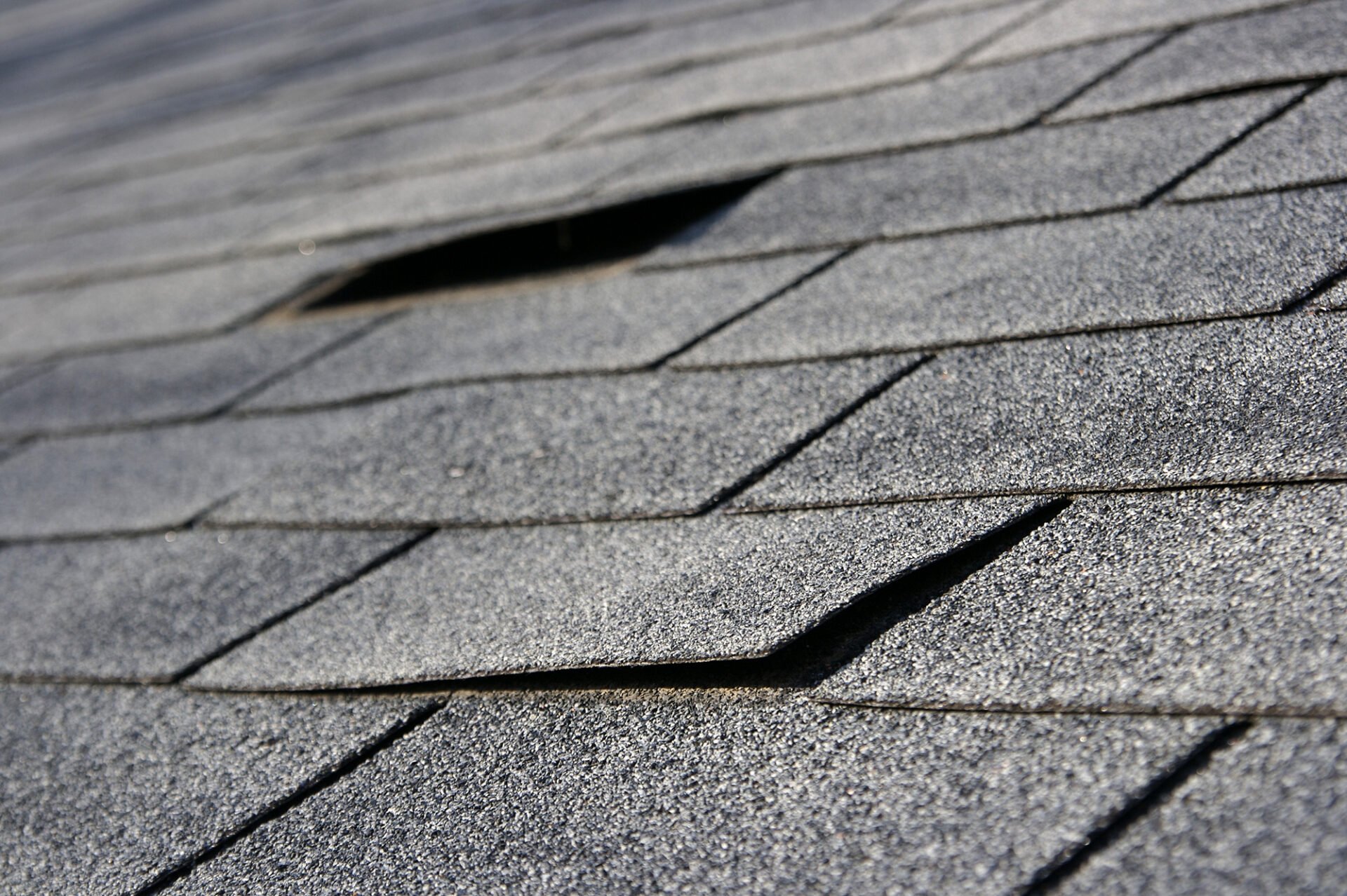 Damaged roof shingles. Hole in roof.