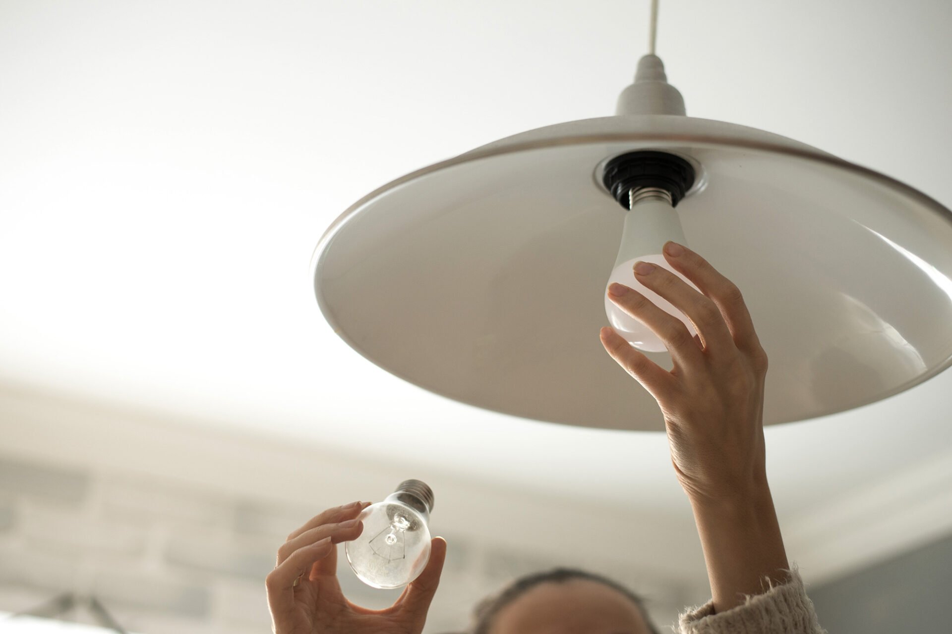 A person changing a light bulb. Hand holding a bulb.