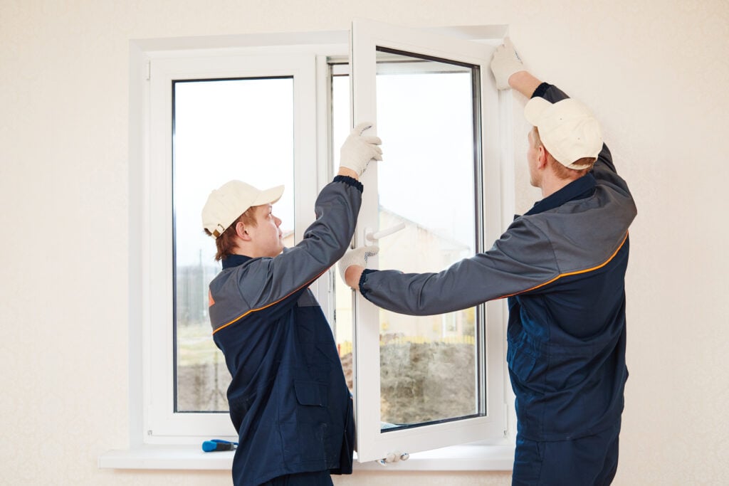 two professionals installing a window