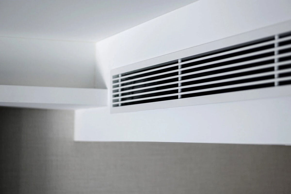 An air conditioning vent on a white ceiling. Close up.