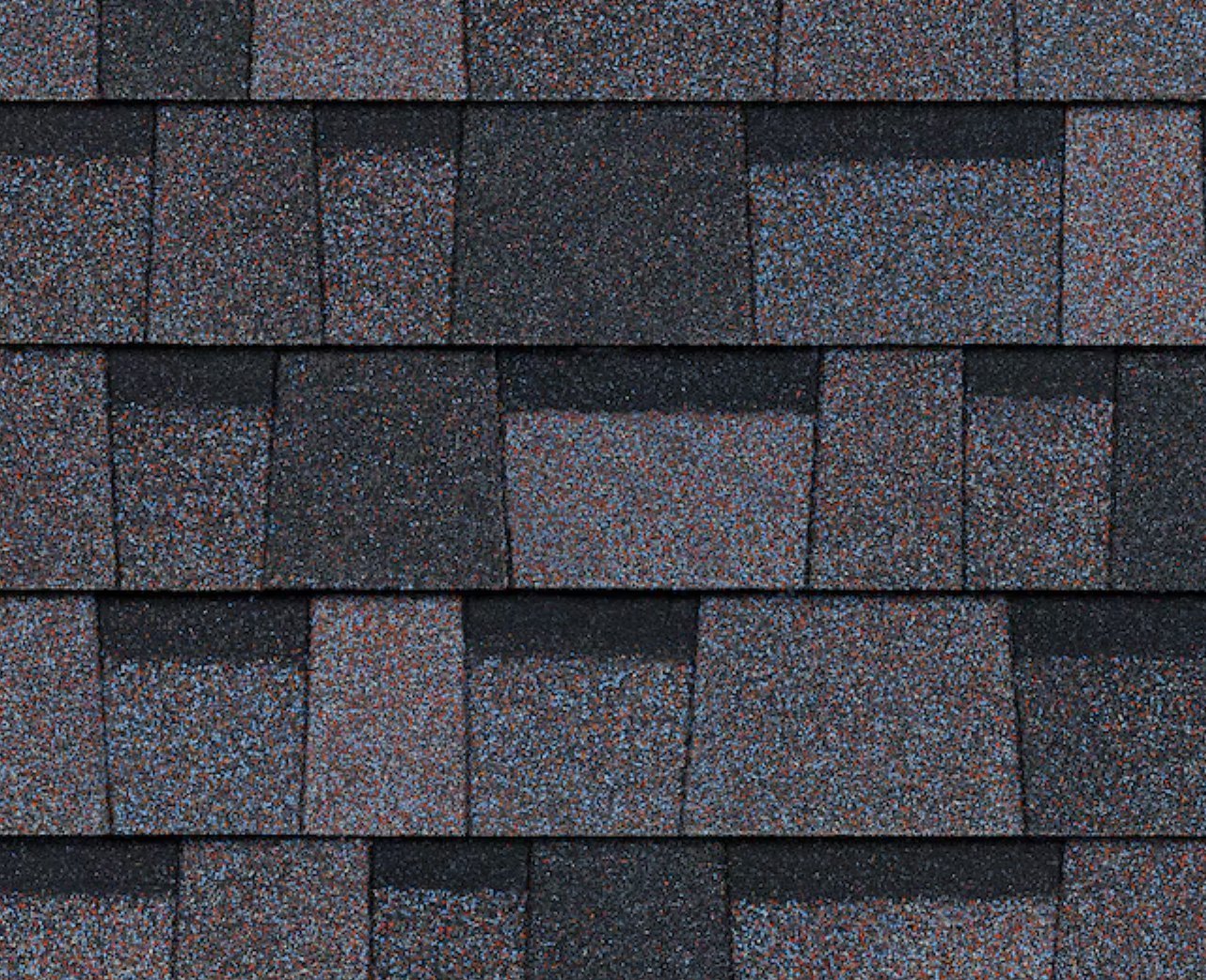 Close-up of Dark Grey Roof Shingles Dark grey roof shingles with red and blue speckles. The shingles are rectangular and overlapping.