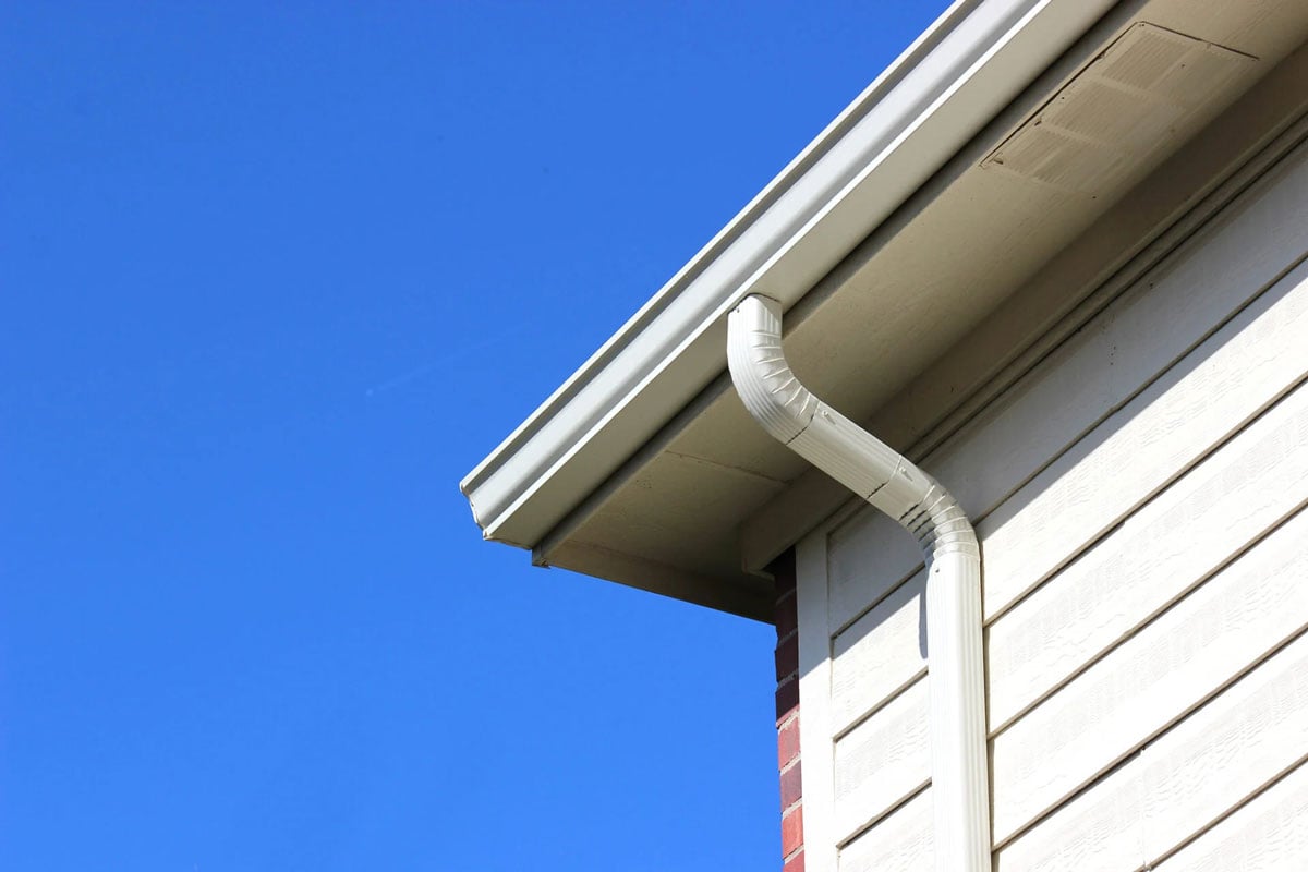House Eaves with Downspout on Siding A house eave with downspout on siding. Close-up view.