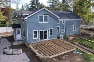 A blue house with a partially built wooden deck
