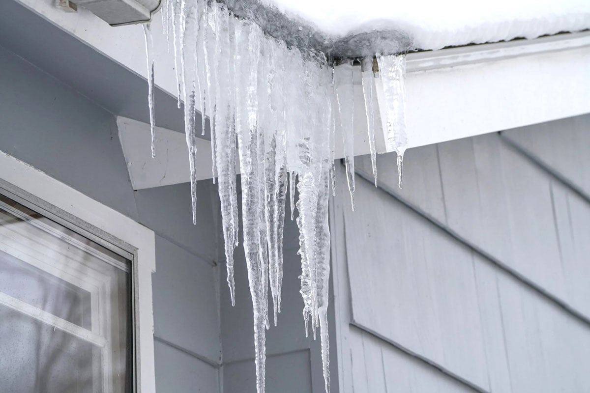 Icicles hanging from house eaves. Winter scene.