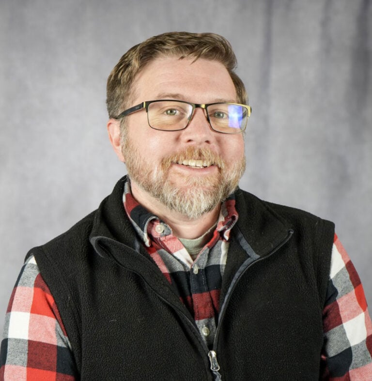 Man with glasses and plaid shirt smiling A man with glasses and a plaid shirt