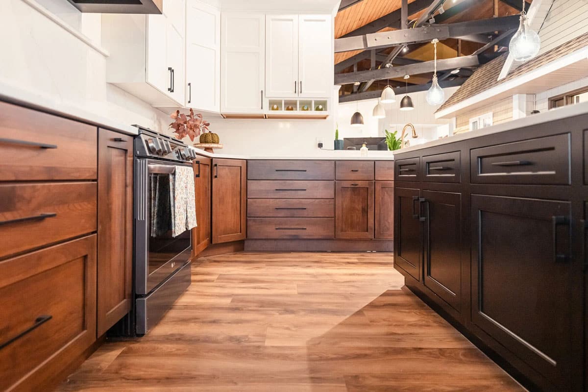 A modern kitchen with dark wooden cabinets and black appliances. The kitchen has a clean and sleek look.