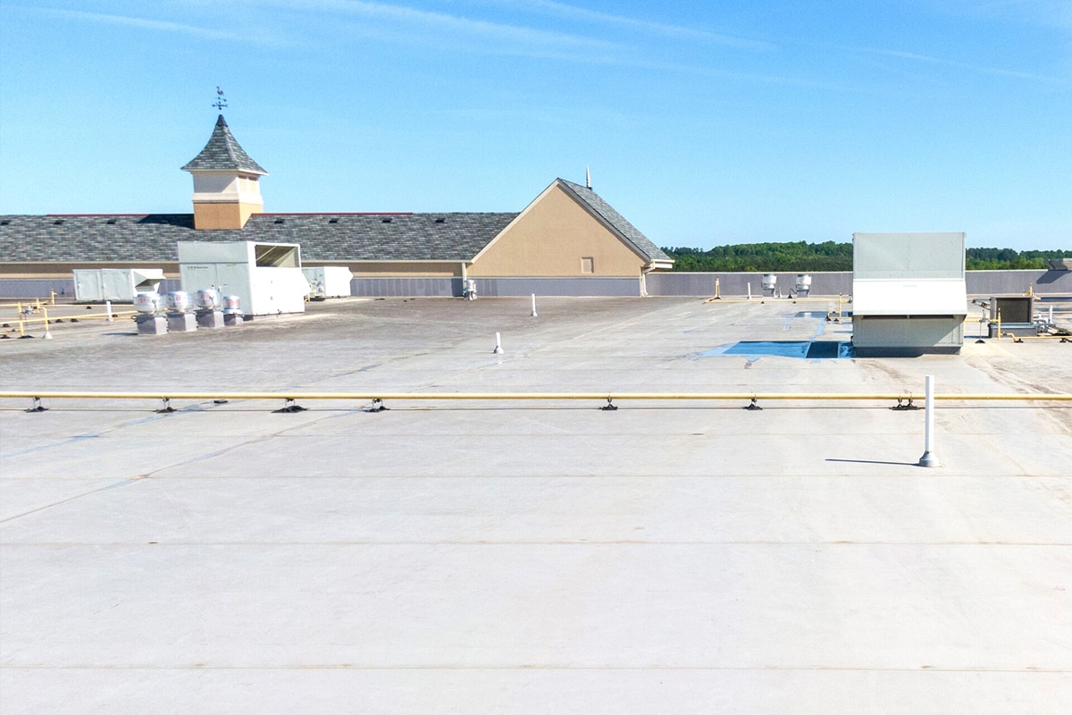 Flat roof with parapet. Building with tower in background.