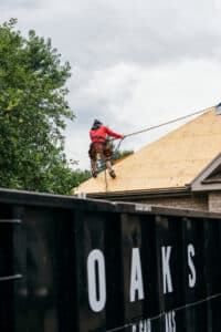 a man in a red jacket working on a roof