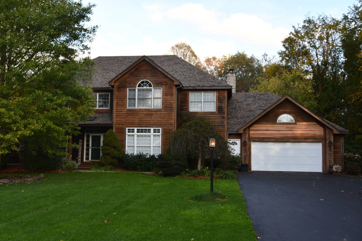 A large house with a garage. A driveway leads to the garage.