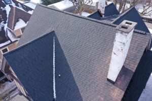 An aerial view of multiple residential rooftops covered in snow during winter.