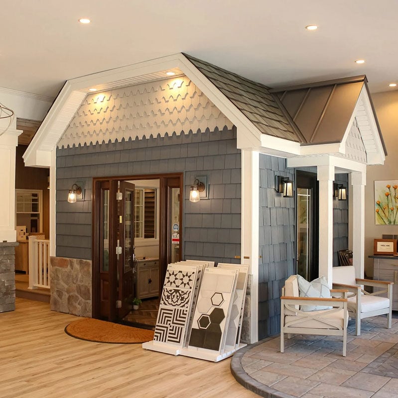A living room with a fireplace and a small house in the middle. The room is well lit.