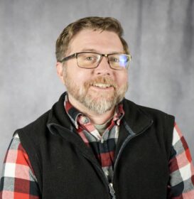 A man with glasses and a plaid shirt
