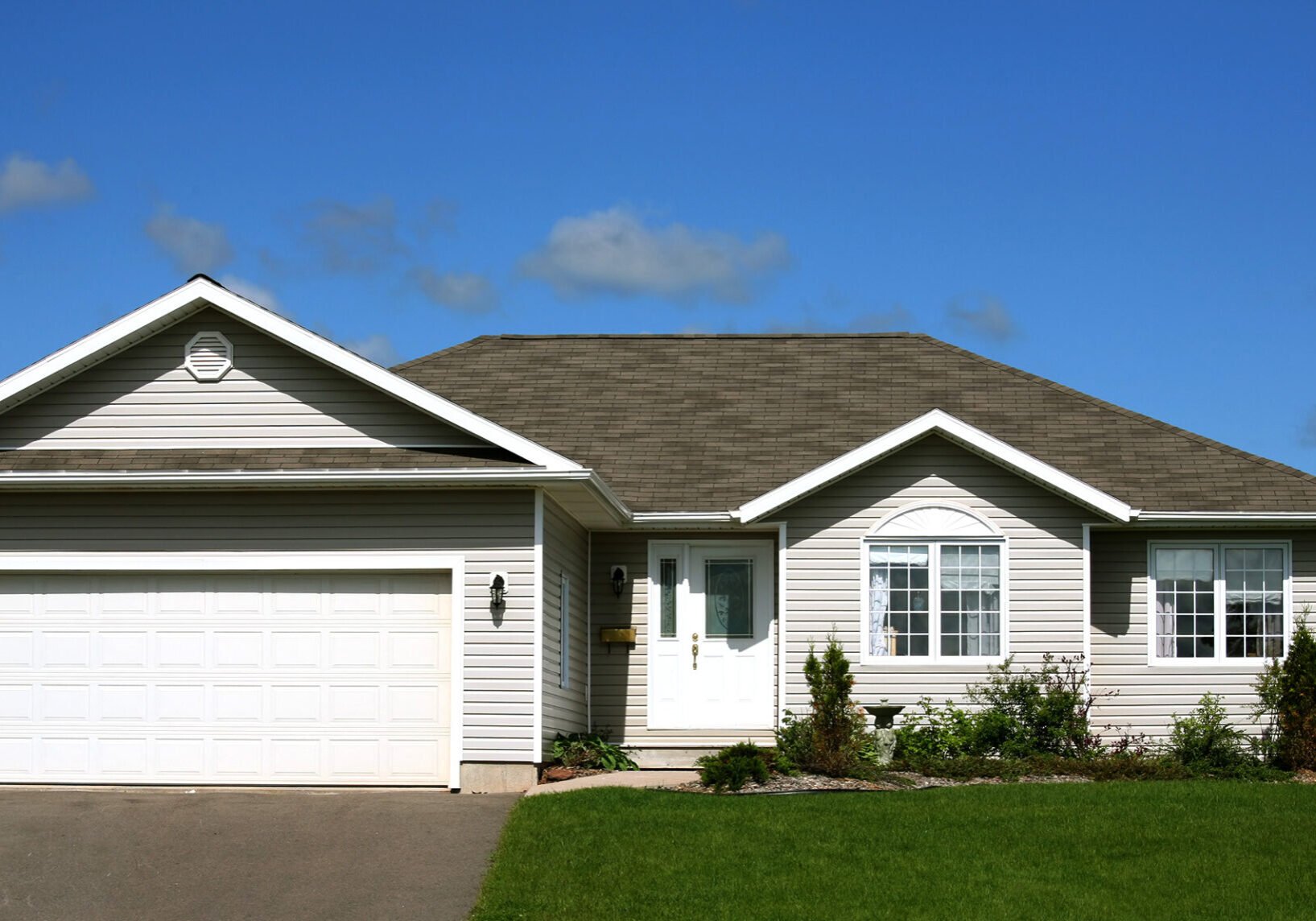 Modern Single Story Home with Garage A modern single story home with a garage. The house features a light exterior with a dark roof.